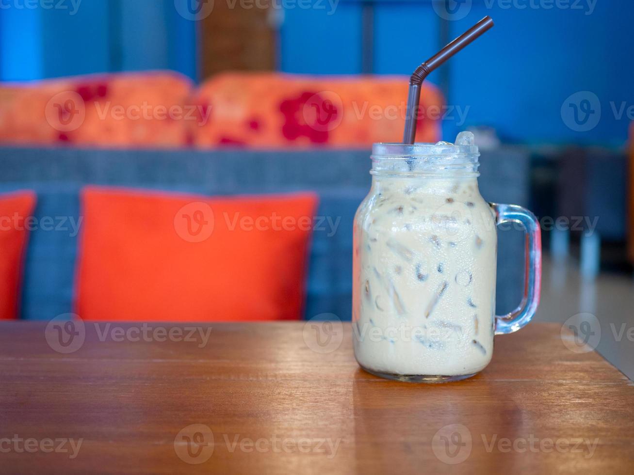 färskt mjölkte i ett glas placerat på ett trägolv. med ledigt utrymme foto