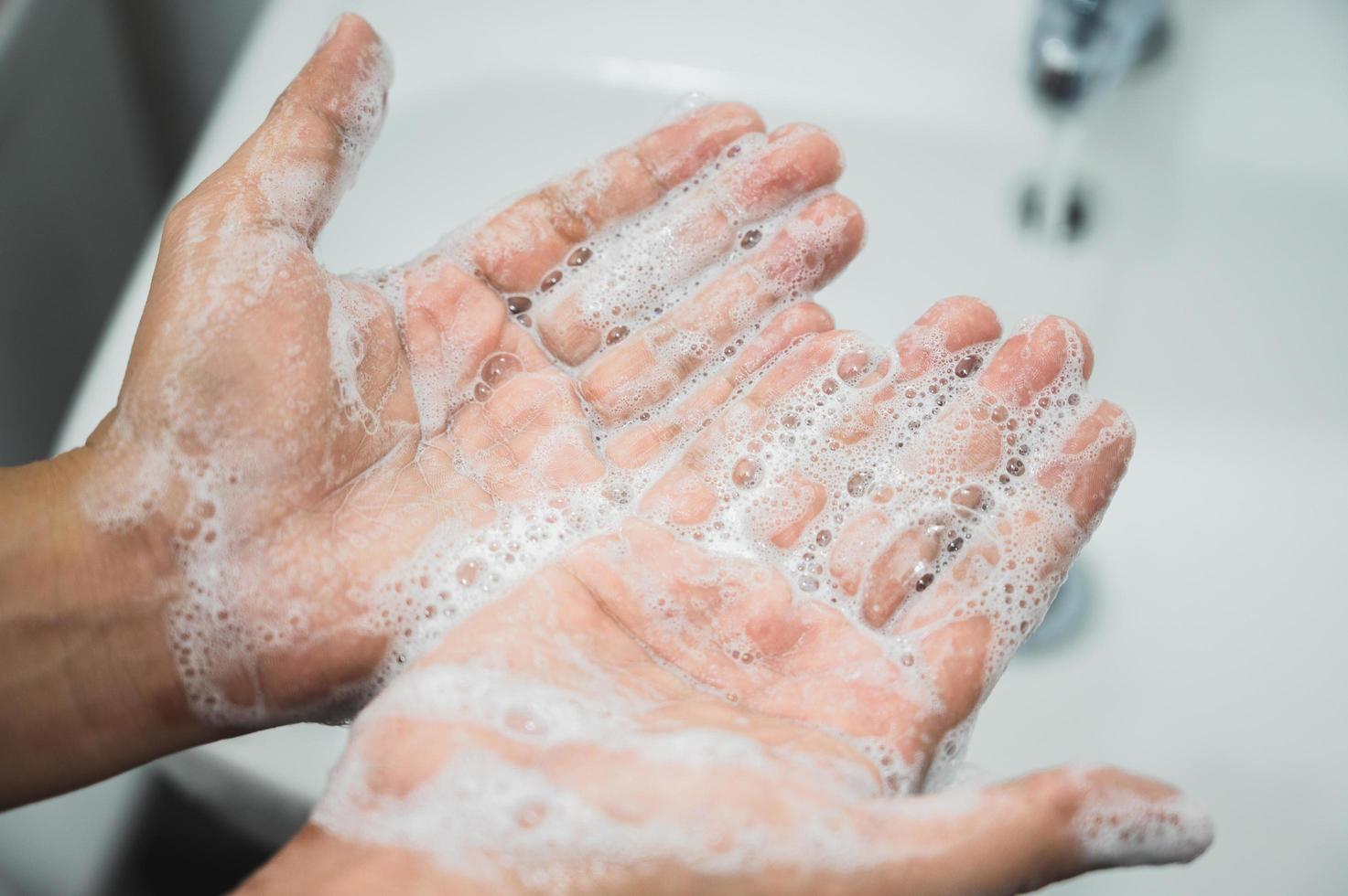 närbild manliga händer tvätta händer med tvål. foto