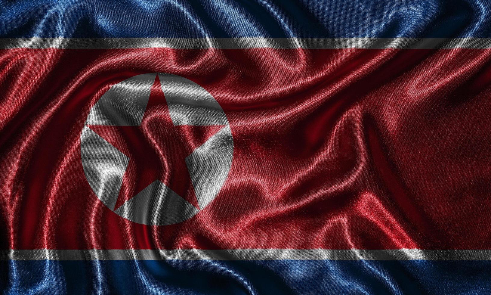 tapeter av Nordkoreas flagga och viftande flagga av tyg. foto