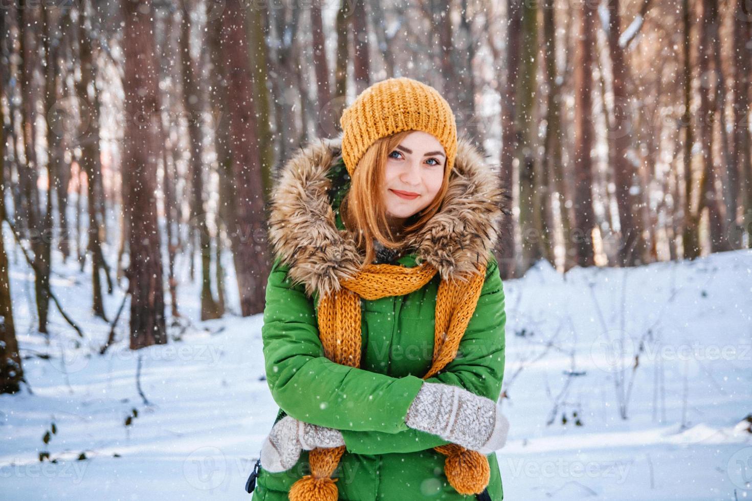 kvinna i vinterkläder på en bakgrund av snötäckt skog foto