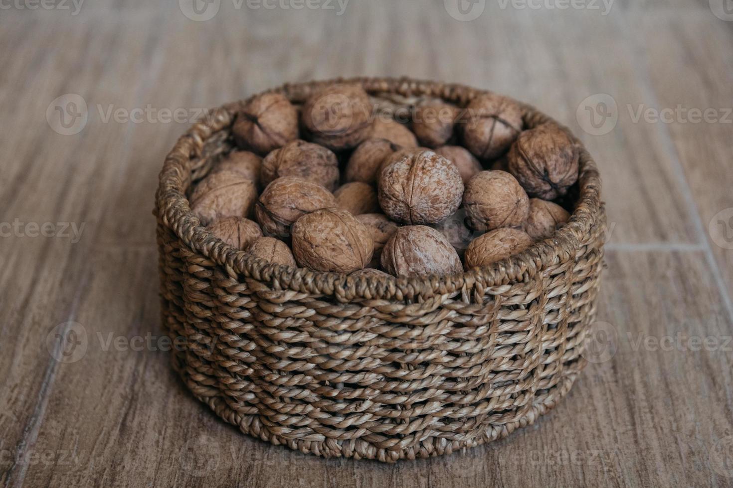 valnötter i en rund korg på träbakgrund foto