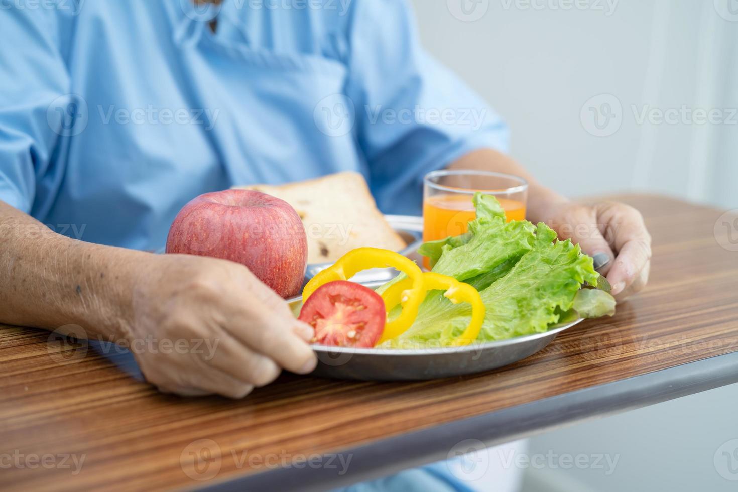 asiatisk senior kvinna patient äter frukost på sjukhus. foto