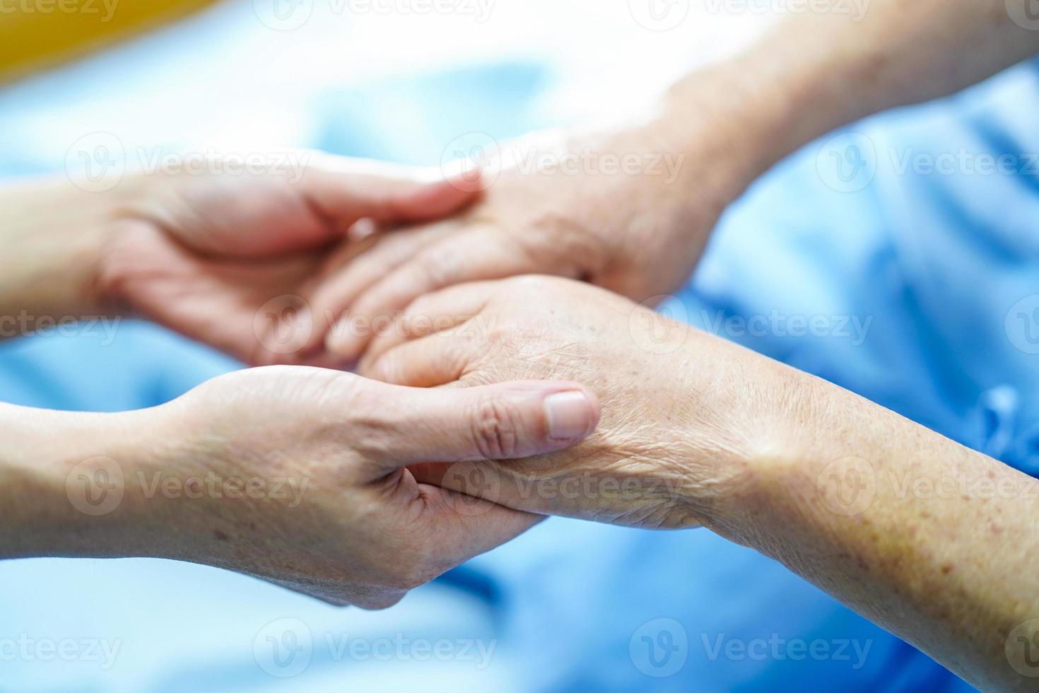 håller rörande händer asiatisk senior kvinna patient med kärlek foto