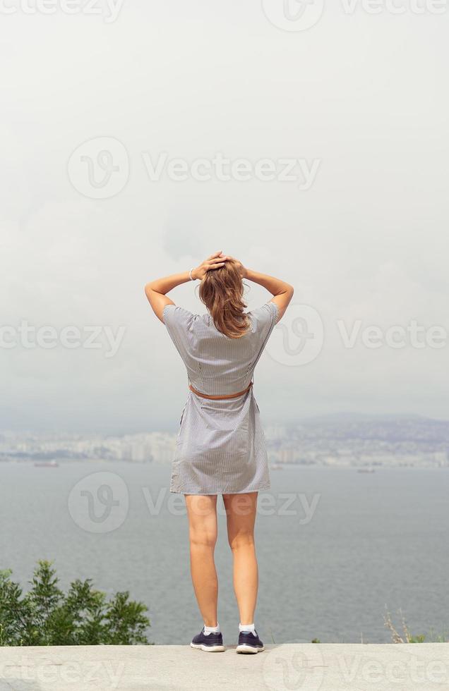 bakifrån av ung kvinna som tittar på stadsbilden foto