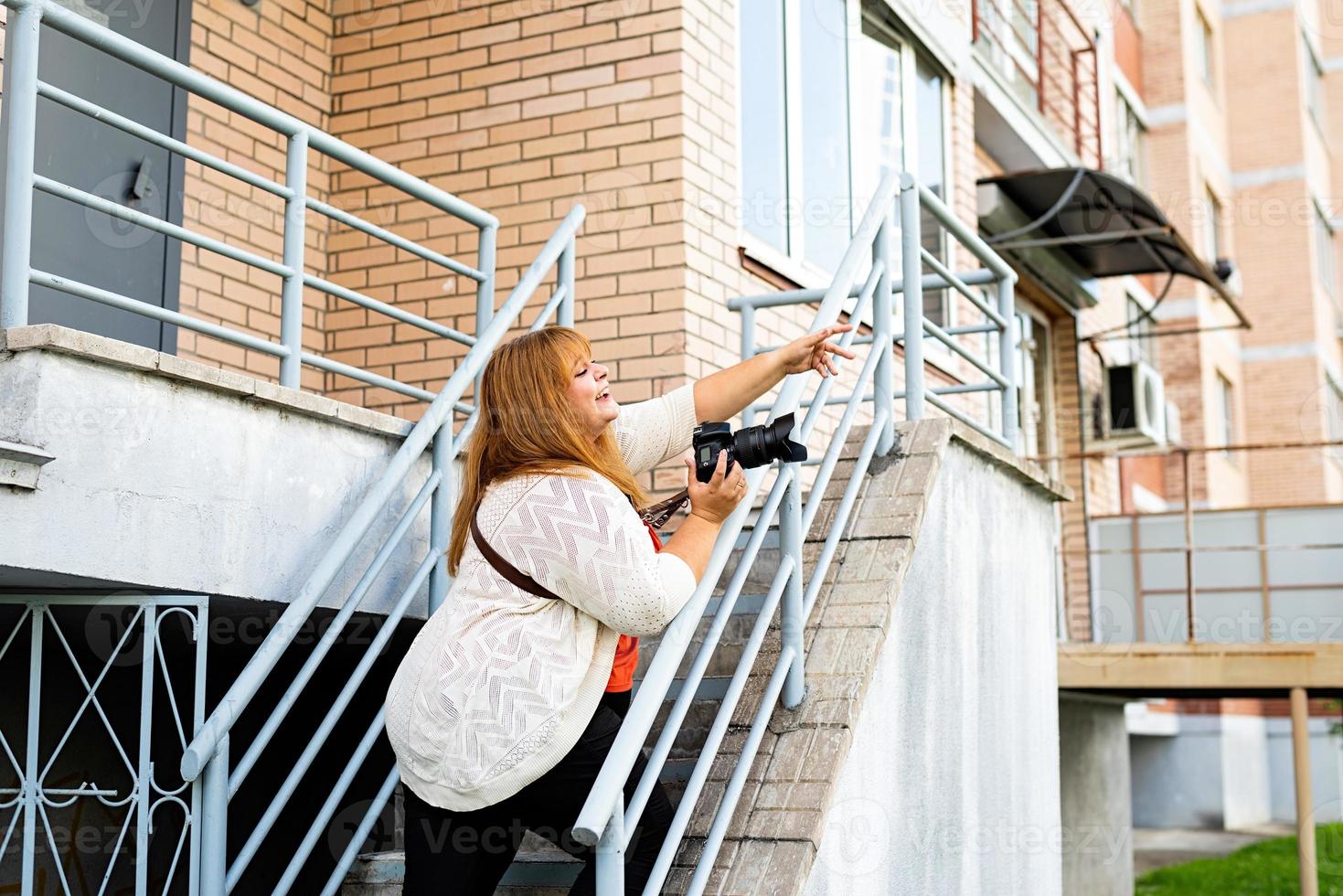 plus size kvinna fotograf arbetar på gatan foto