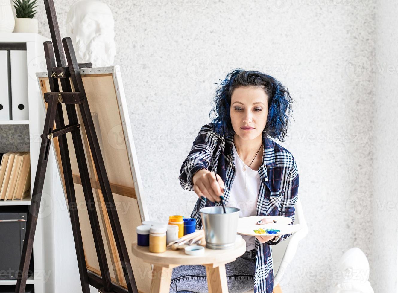 kreativ kvinna med blåfärgat hårmålning i hennes studio foto