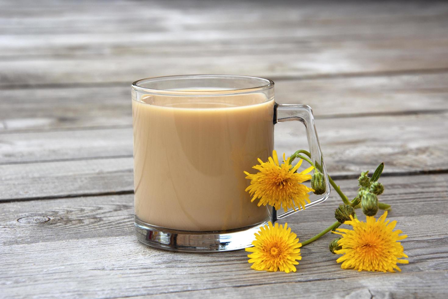 mugg med kakao och gula blommor på en träbakgrund foto