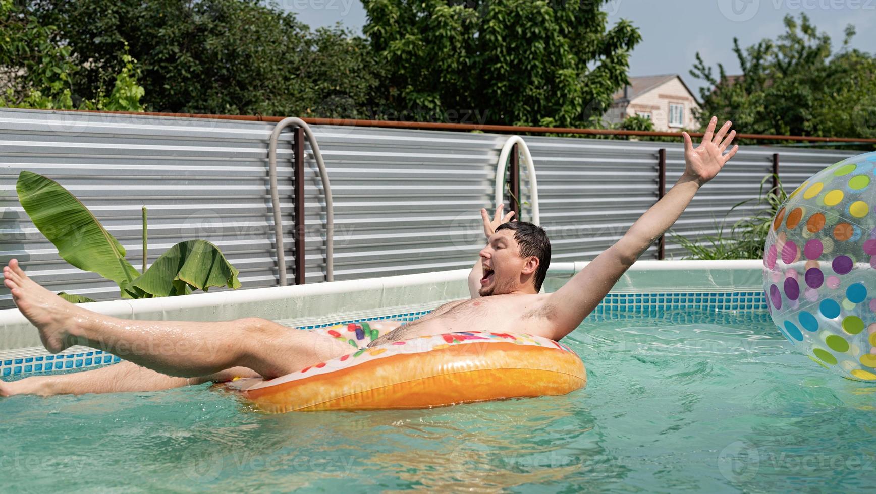 ung man som har kul vid poolen på uppblåsbara simrör foto