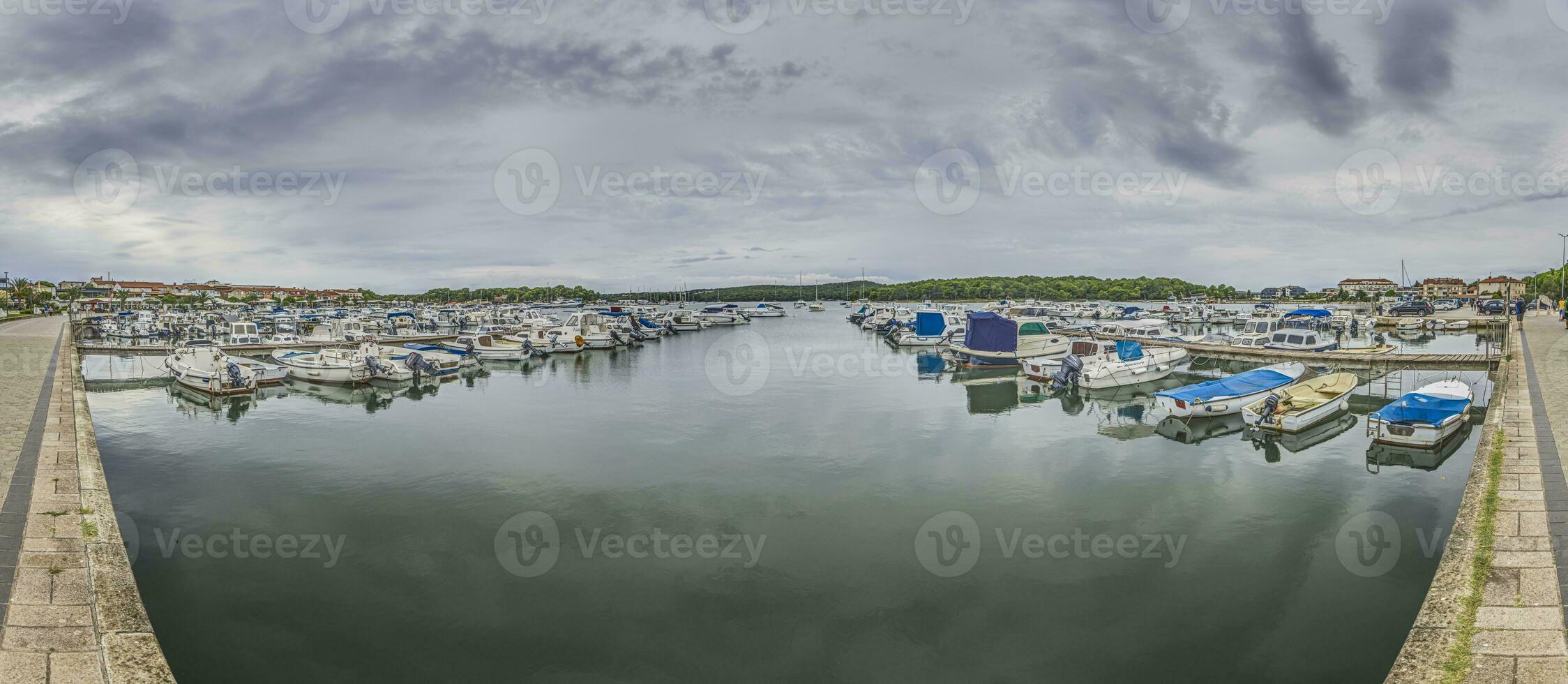 se över en Yacht hamn med dockad fartyg i främre av grumlig himmel foto