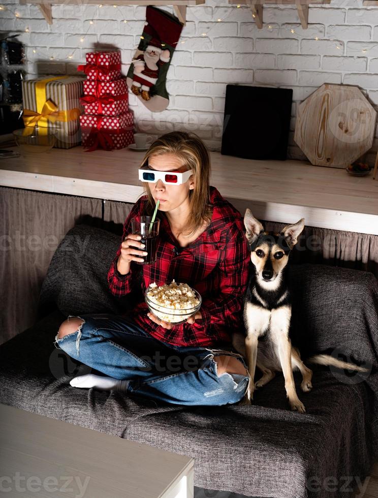 kvinna i 3D -glasögon som tittar på filmer hemma på natten vid jul foto