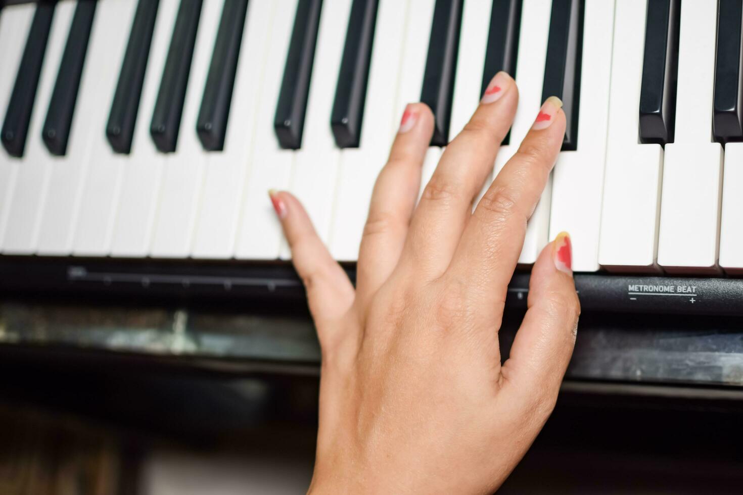 asiatisk pojke spelar de synthesizer eller piano. söt liten unge inlärning på vilket sätt till spela piano. barnets händer på de tangentbord inomhus. foto