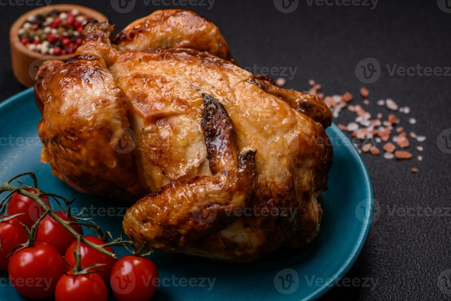 Krispig utsökt hela bakad kyckling med grönsaker, salt och kryddor foto