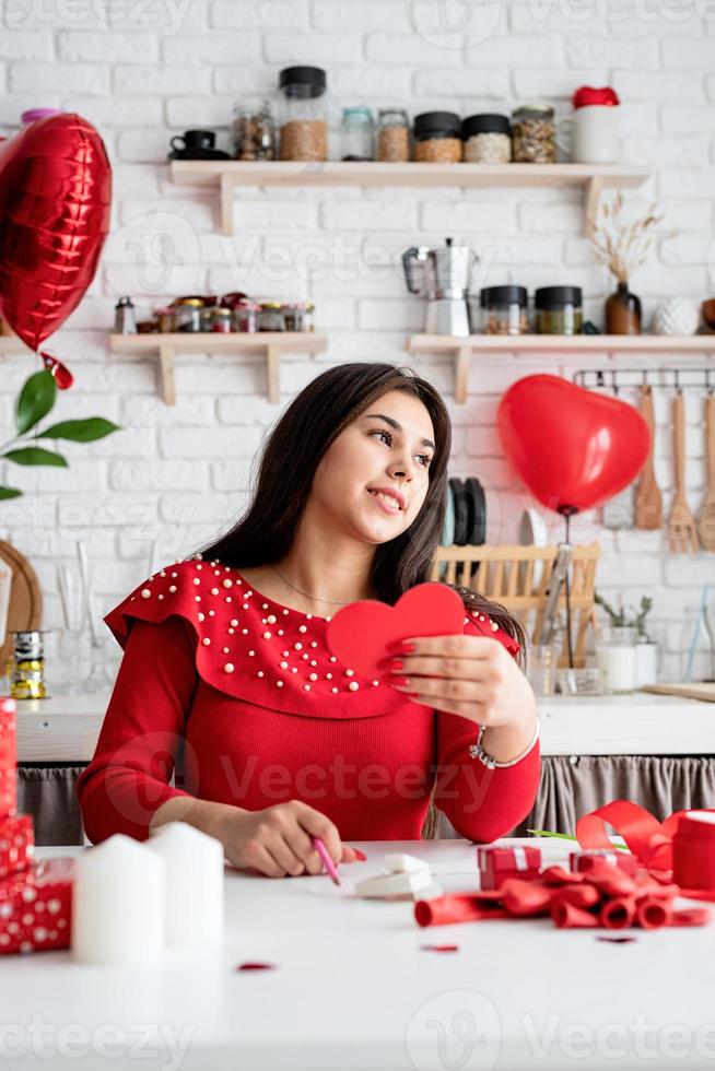 kvinna skriver kärleksbrev sitter vid det inredda köket foto