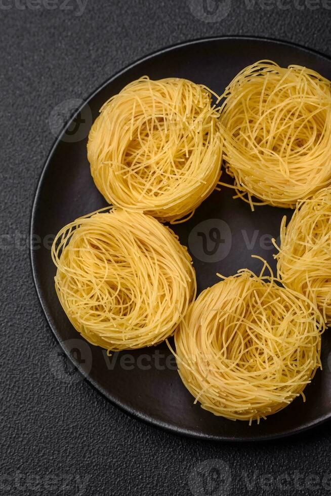 rå capellini pasta eller spaghetti med salt och kryddor foto