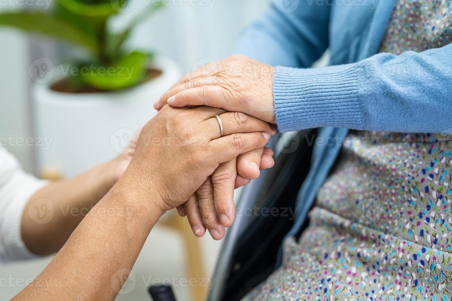 håller händerna asiatisk senior kvinna med kärlek. foto