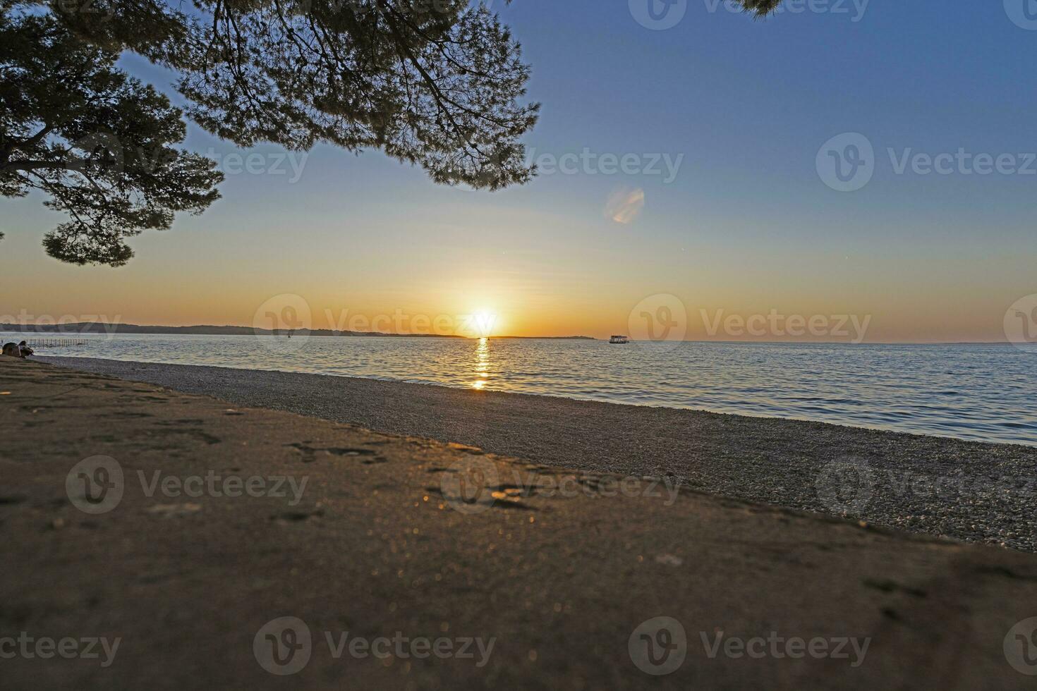 solnedgång på de strand i de kroatisk kust stad av fazana foto