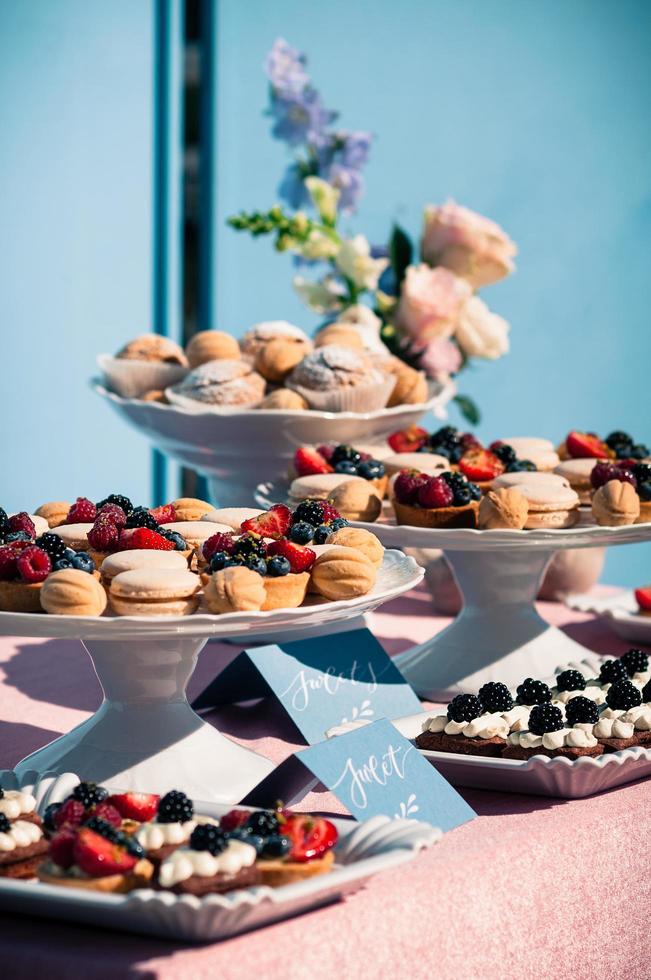 godisbuffé med muffins, makroner och andra desserter foto