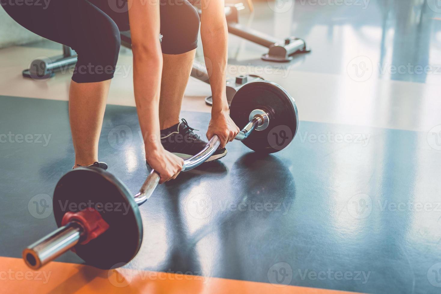 närbild av sport kvinna lyfta vikt i fitness gym foto