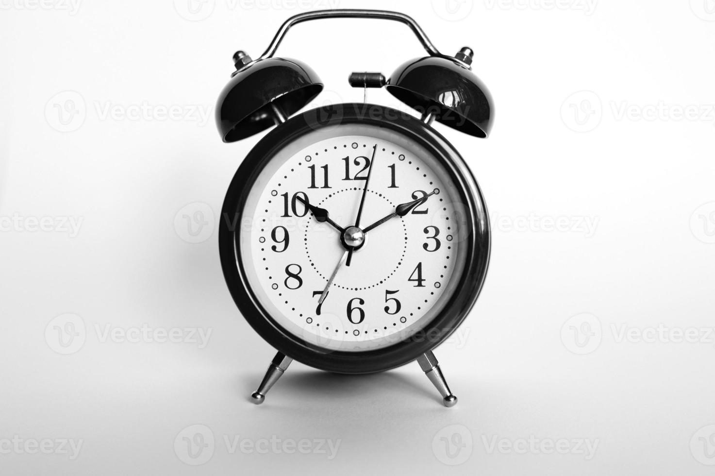 svart rund analog väckarklocka isolerad på vit bakgrund. tid 1010. tonad i svartgrå färg foto