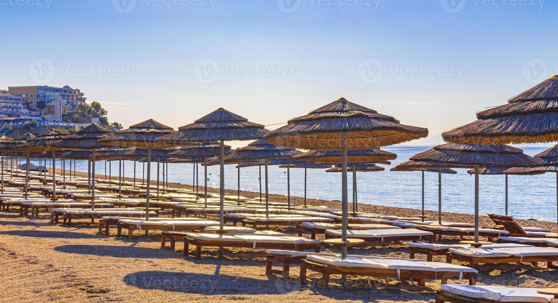 solstolar och parasoller på stranden kos island greece. foto