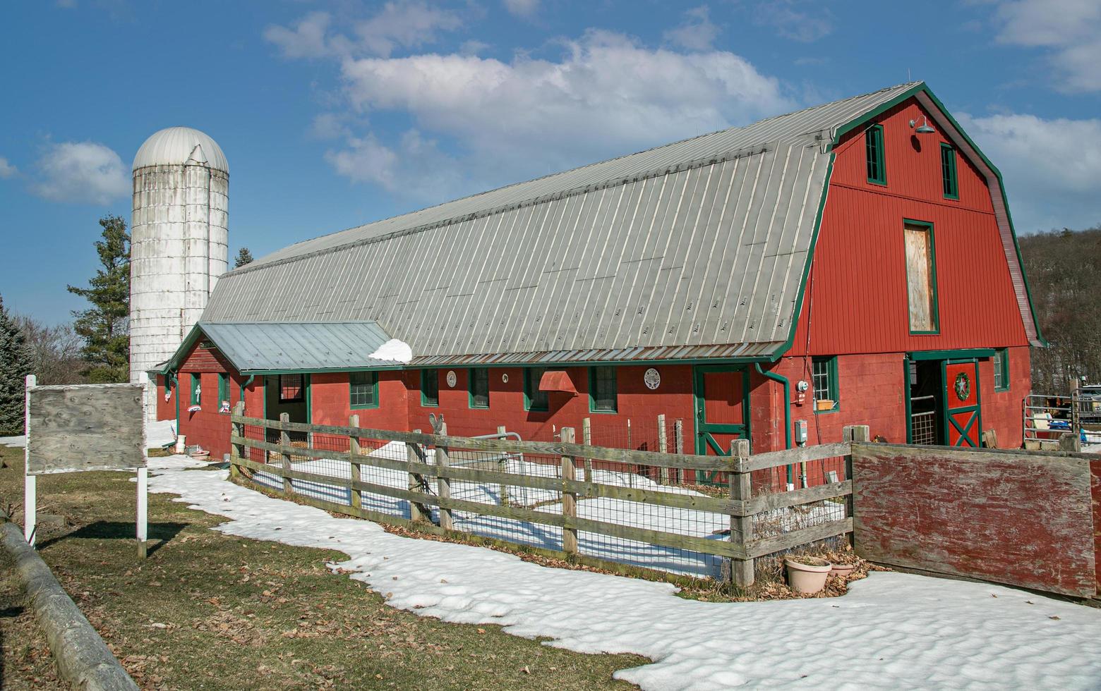 röd ladugård med en vit silo foto