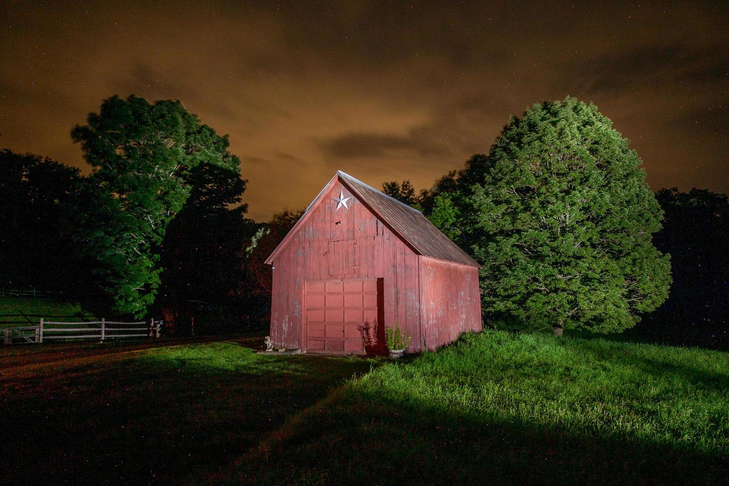 ljusmålad ladugård på natten i vermont foto