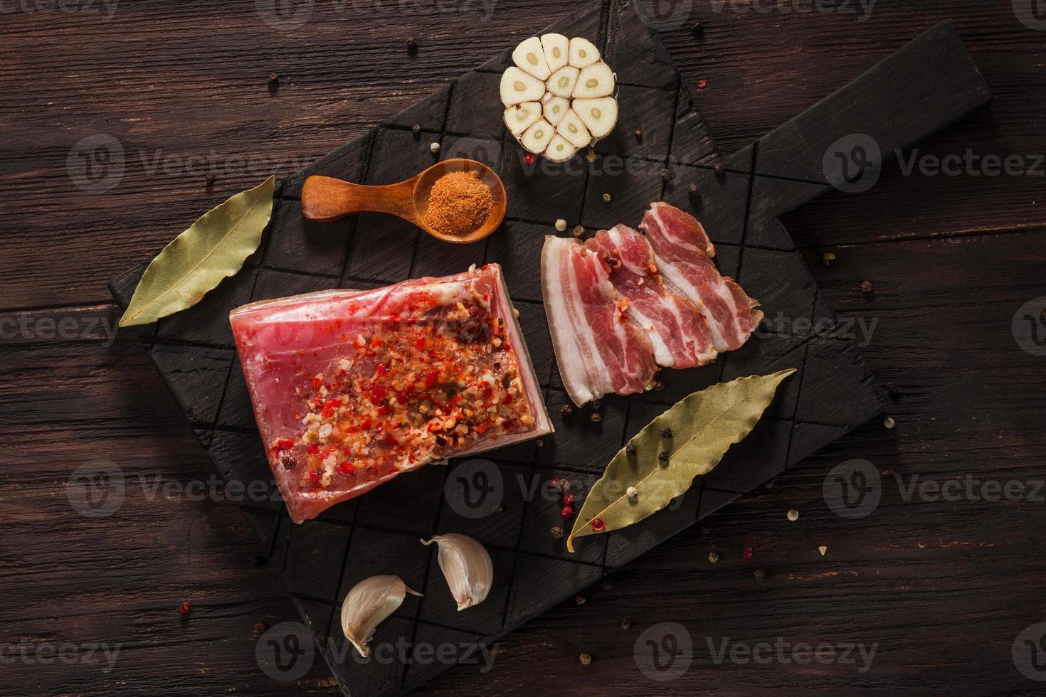 saltat torkat bacon med kryddor och lagerblad och vitlök foto