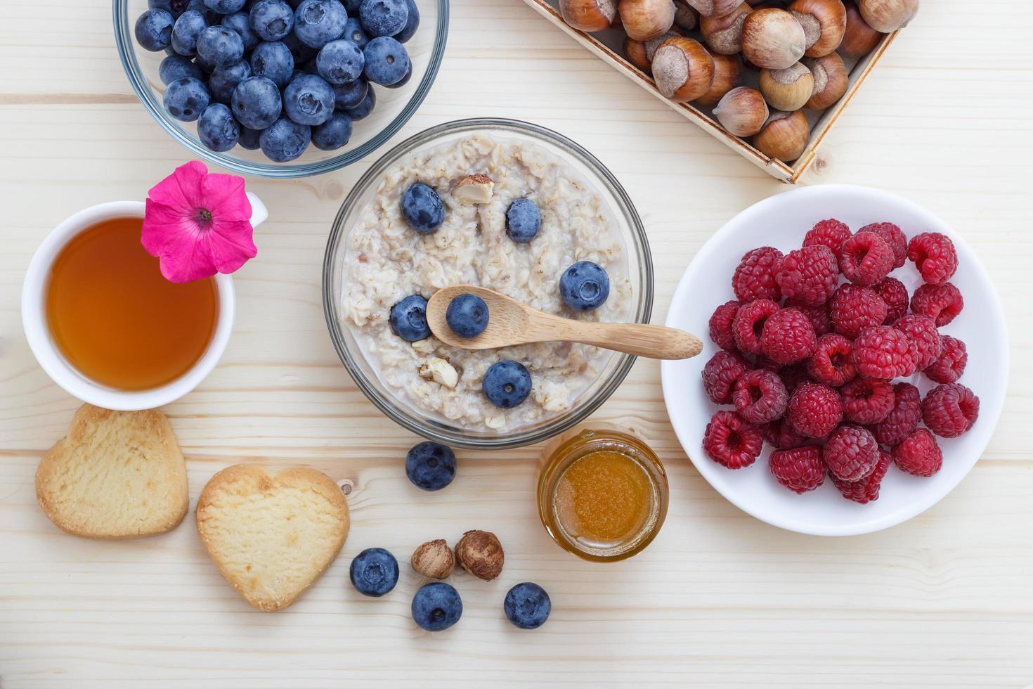 en hälsosam frukost med havregryn, blåbär, hallon, hasselnötter foto