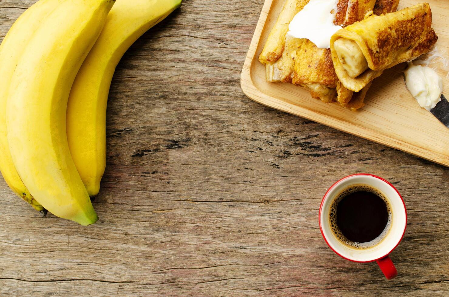 banan fransk toast och svart kaffe röd kopp, plats för din text foto