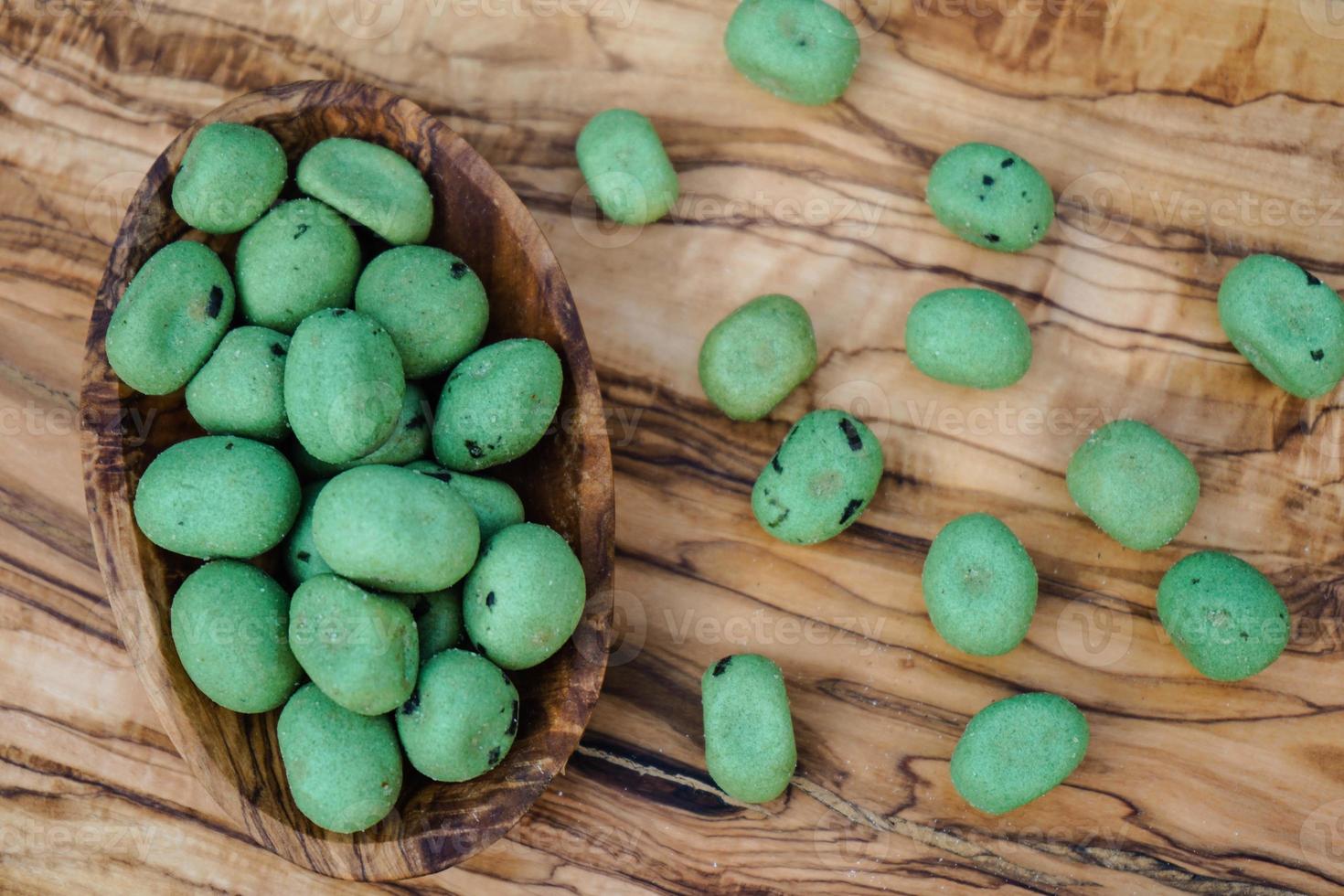 kryddiga wasabinötter på olivträ foto