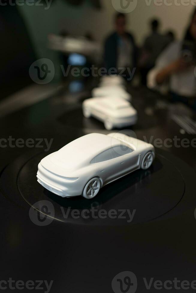 en miniatyr- modell av en porsche bil. vit bil modeller är visas som utställningar den där människor se på. foto