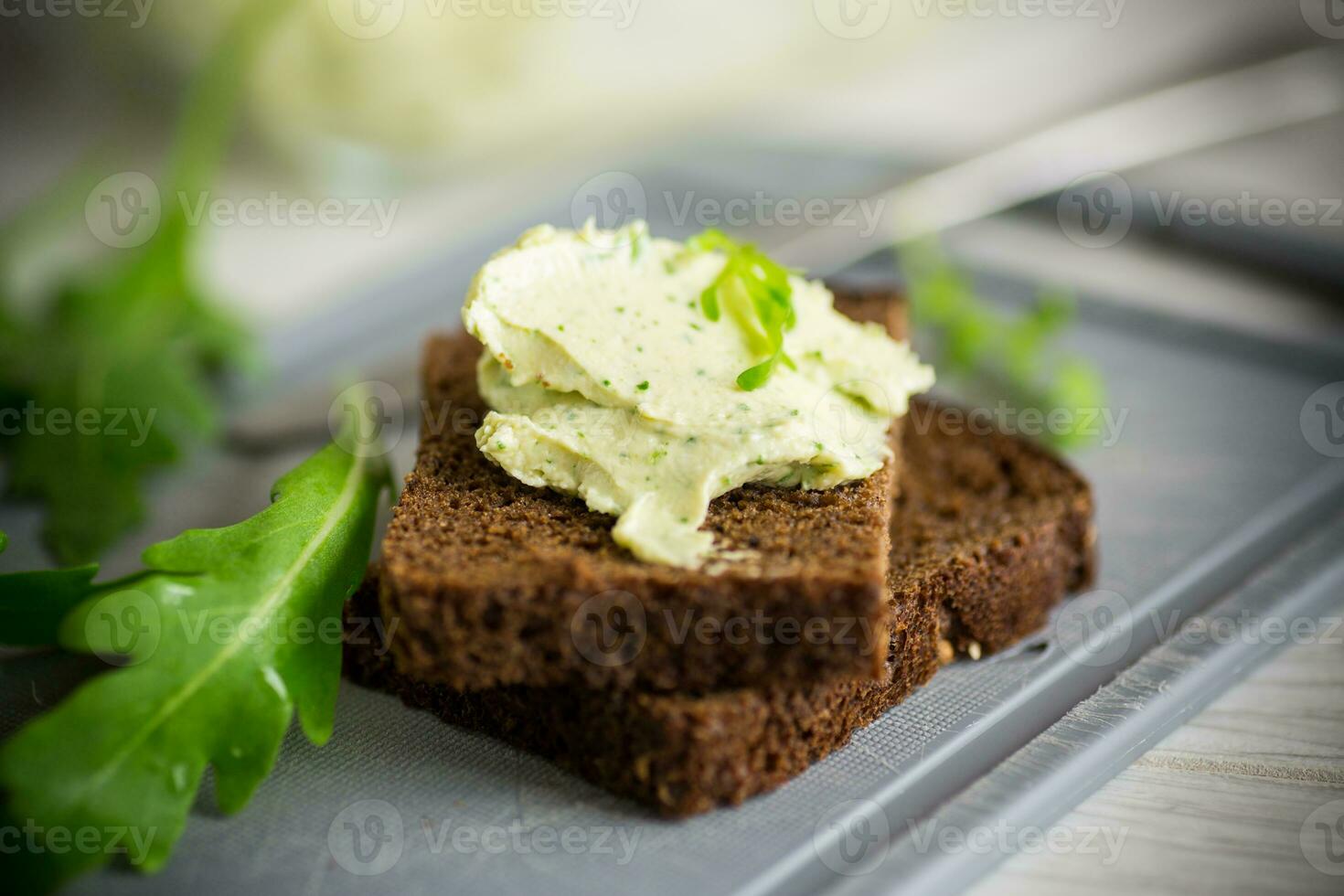 bröd ost spridning med vitlök och arugula på mörk bröd foto