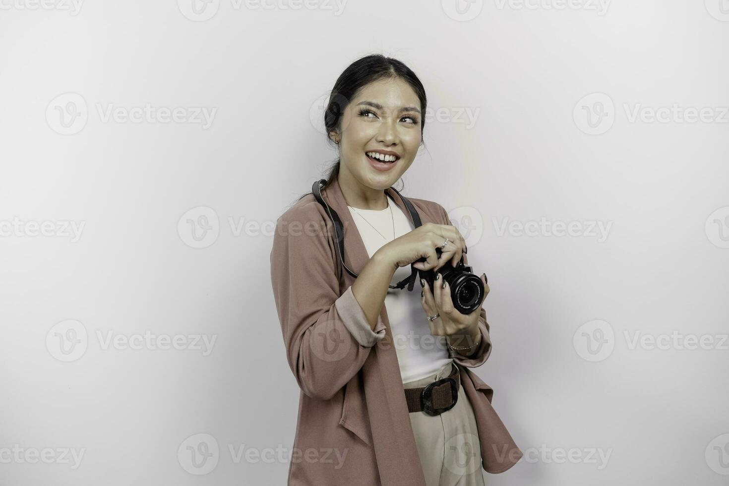 glad ung asiatisk kvinna turist stående med kamera tar Foto isolerat på vit studio bakgrund