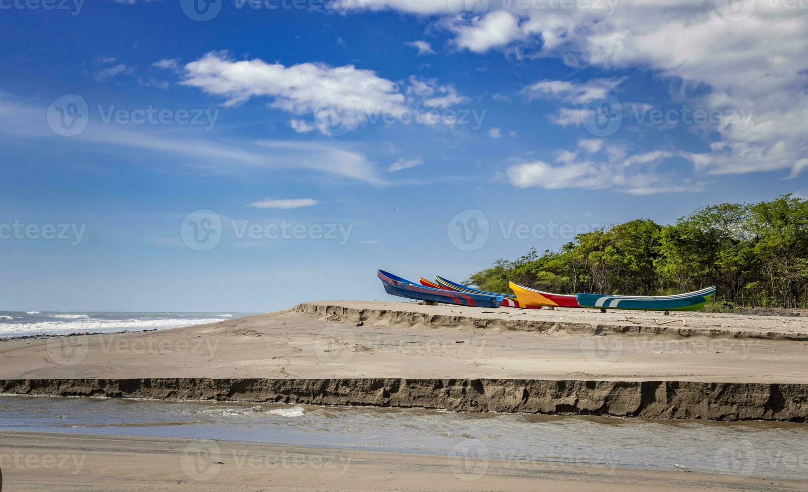 fyra båtar parkerad på de sand, fiske båtar parkerad nära de hav, båtar stranded på de hav Strand med blå himmel foto