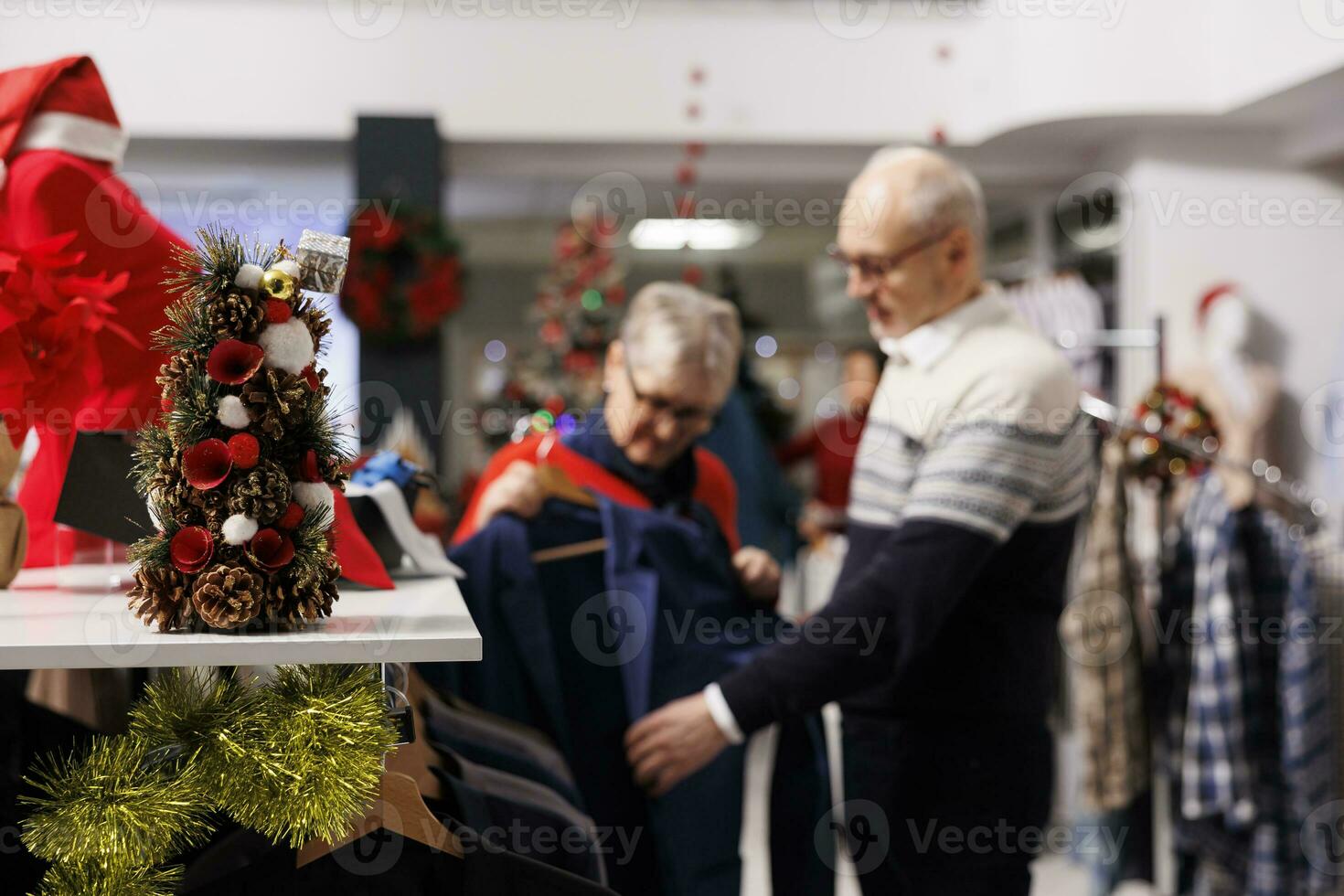 selektiv fokus av kunder granskning kostym jacka på ställ, ser för festlig Kläder till ha på sig på jul eve middag. personer kontroll blazers tyg i detaljhandeln Lagra, formell klädsel utlopp. foto