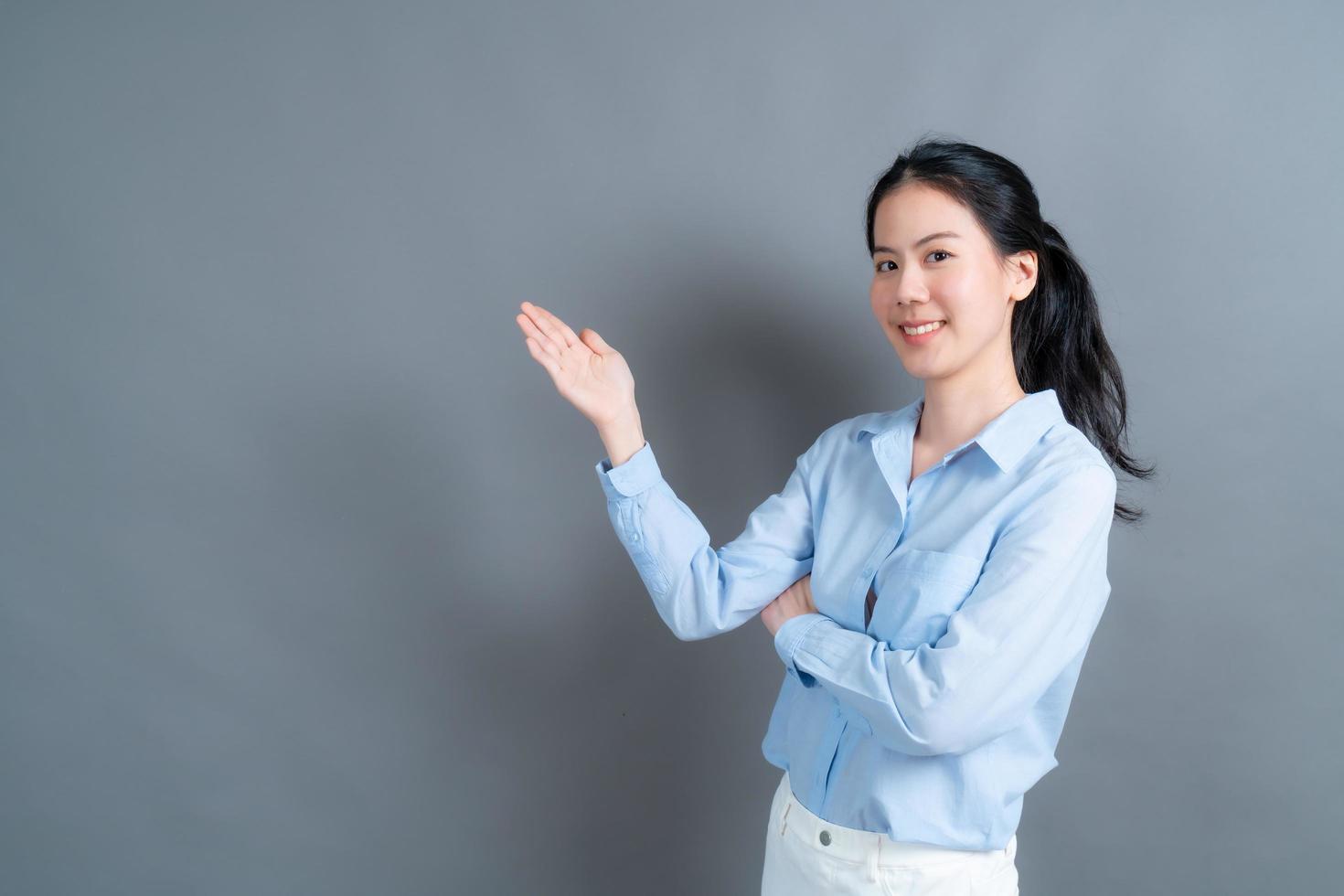 asiatisk kvinna med handen som presenterar på sidan foto