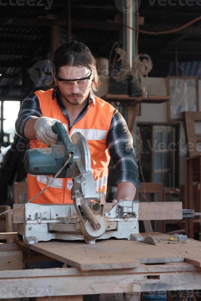 ung kaukasisk snickare arbetar i trämöbelfabrik, foto
