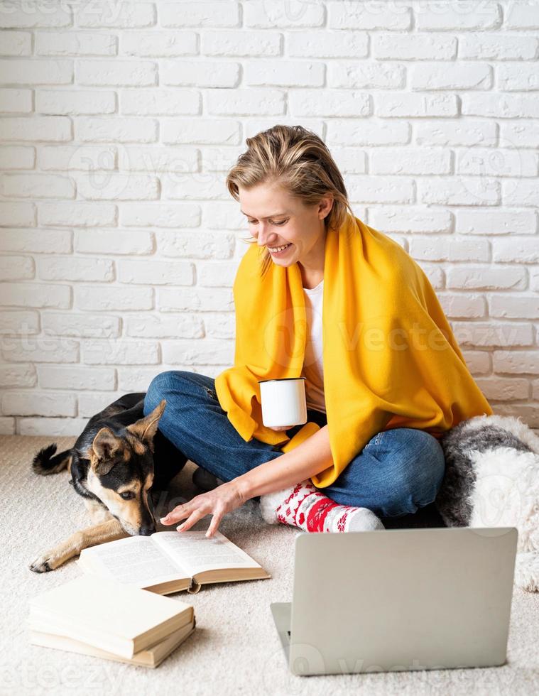 kvinna som sitter på golvet med sina hundar som dricker kaffe foto