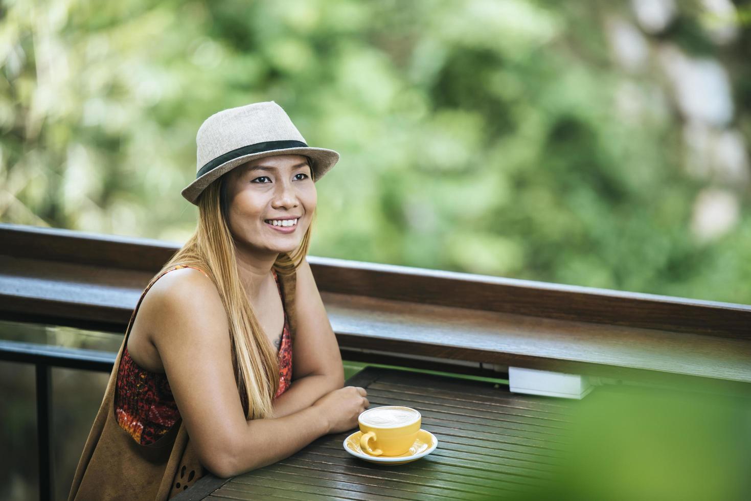 glad ung kvinna med lattekaffe på morgonen foto