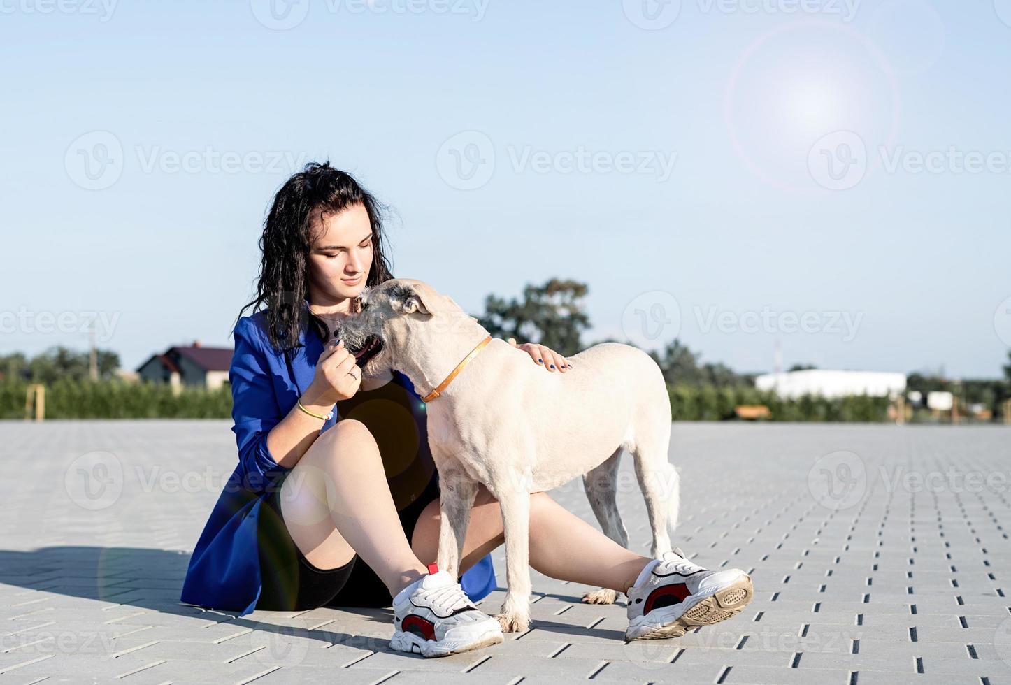 ung attraktiv kvinna som leker med sin hund i parken foto