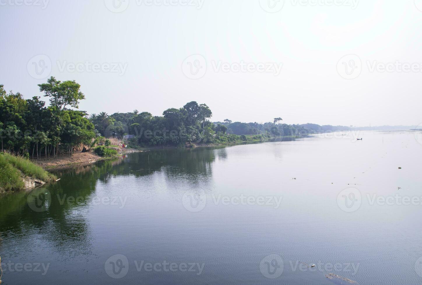reflexion av träd i de sjö vatten mot de blå himmel landskap landsbygden i bangladesh foto