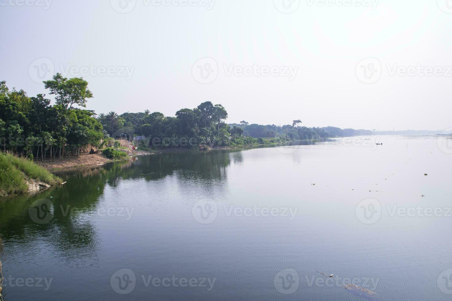 reflexion av träd i de sjö vatten mot de blå himmel landskap landsbygden i bangladesh foto