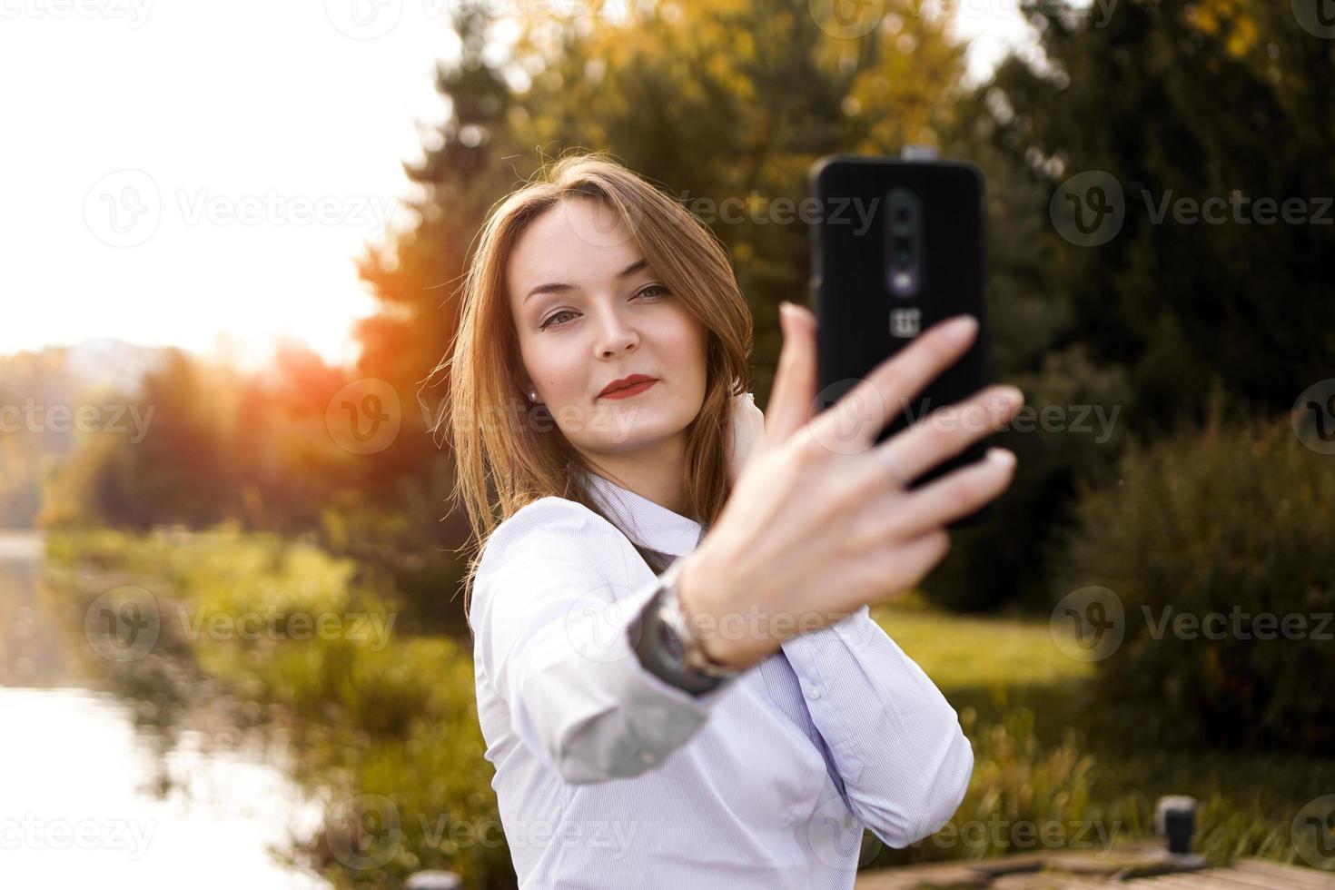 porträtt av glad ung kvinna som gör selfie foto