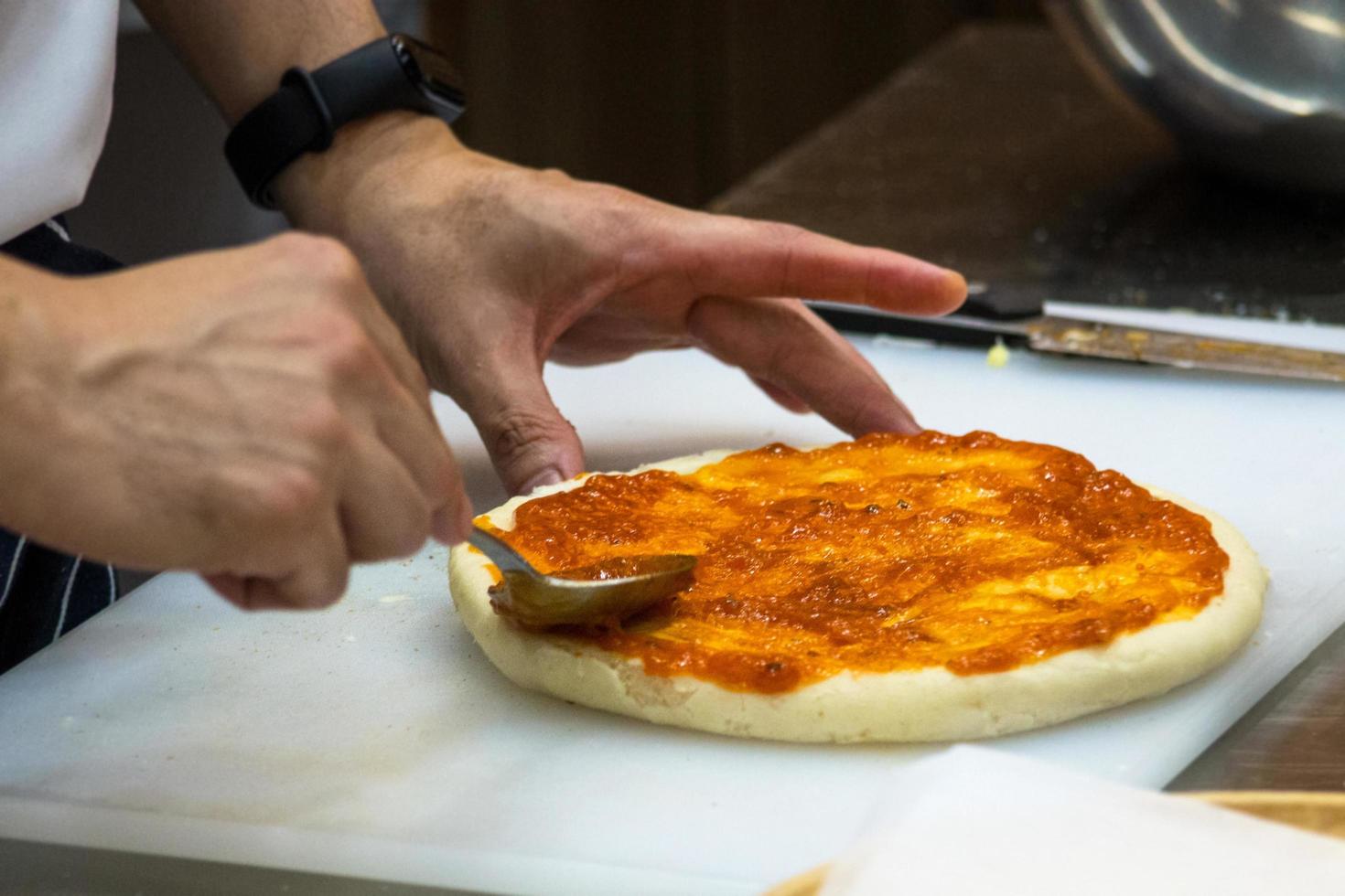 kock som förbereder pizza, processen att göra pizza foto