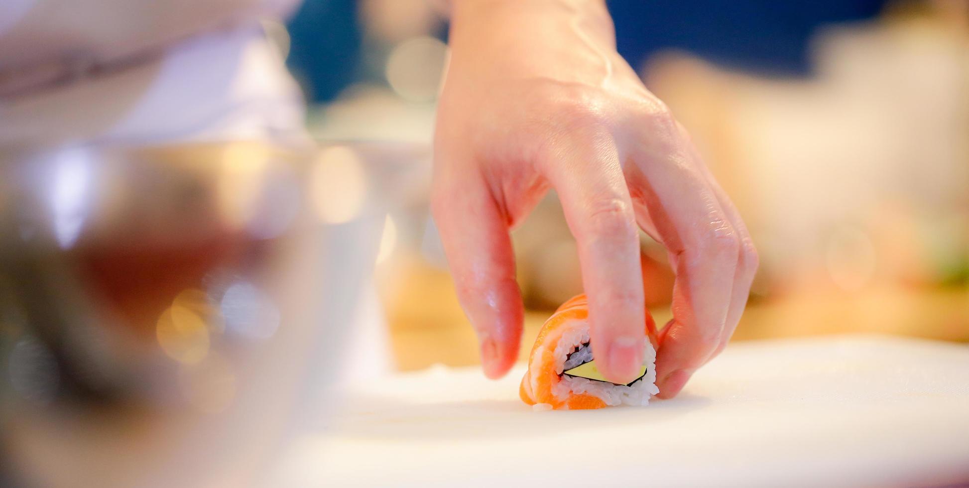 kockhänder som förbereder japansk mat, kock som gör sushi foto