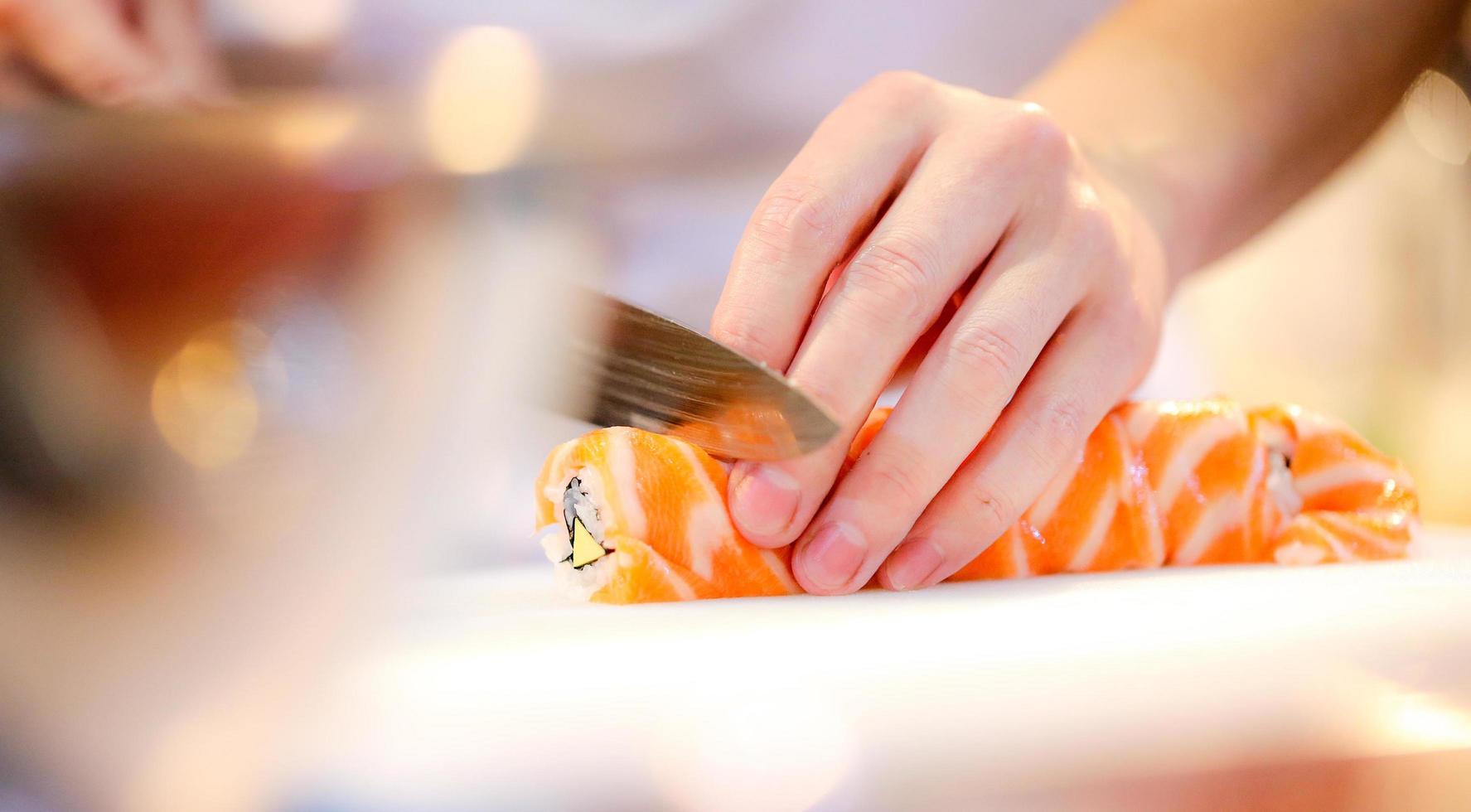 kockhänder som förbereder japansk mat, kock som gör sushi foto