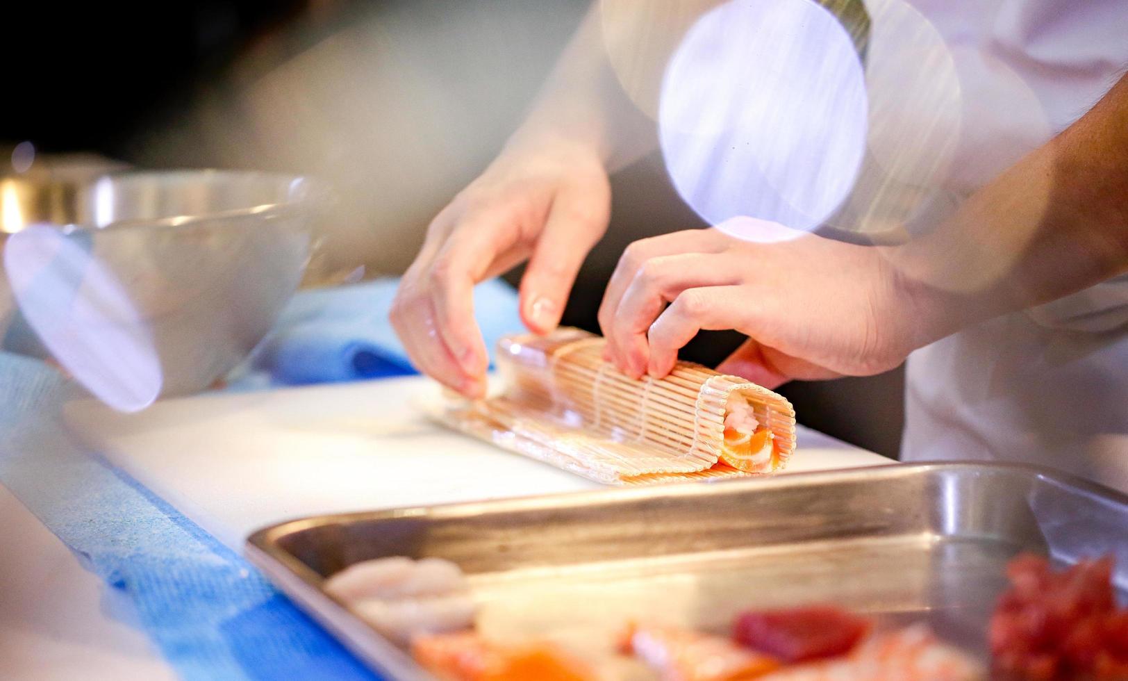 kockhänder som förbereder japansk mat, kock som gör sushi foto