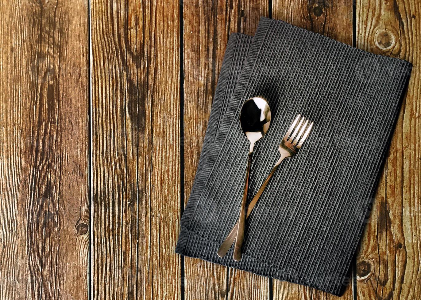 gaffel och sked servett eller servett på trä bakgrund foto