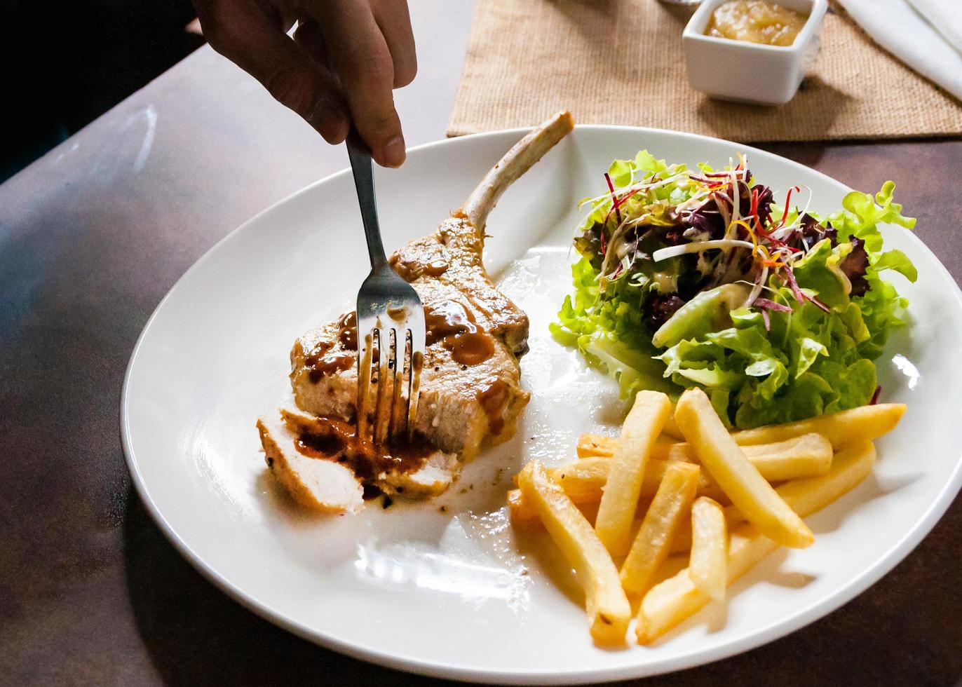 fläskkotlettstek med sallad och pommes frites foto