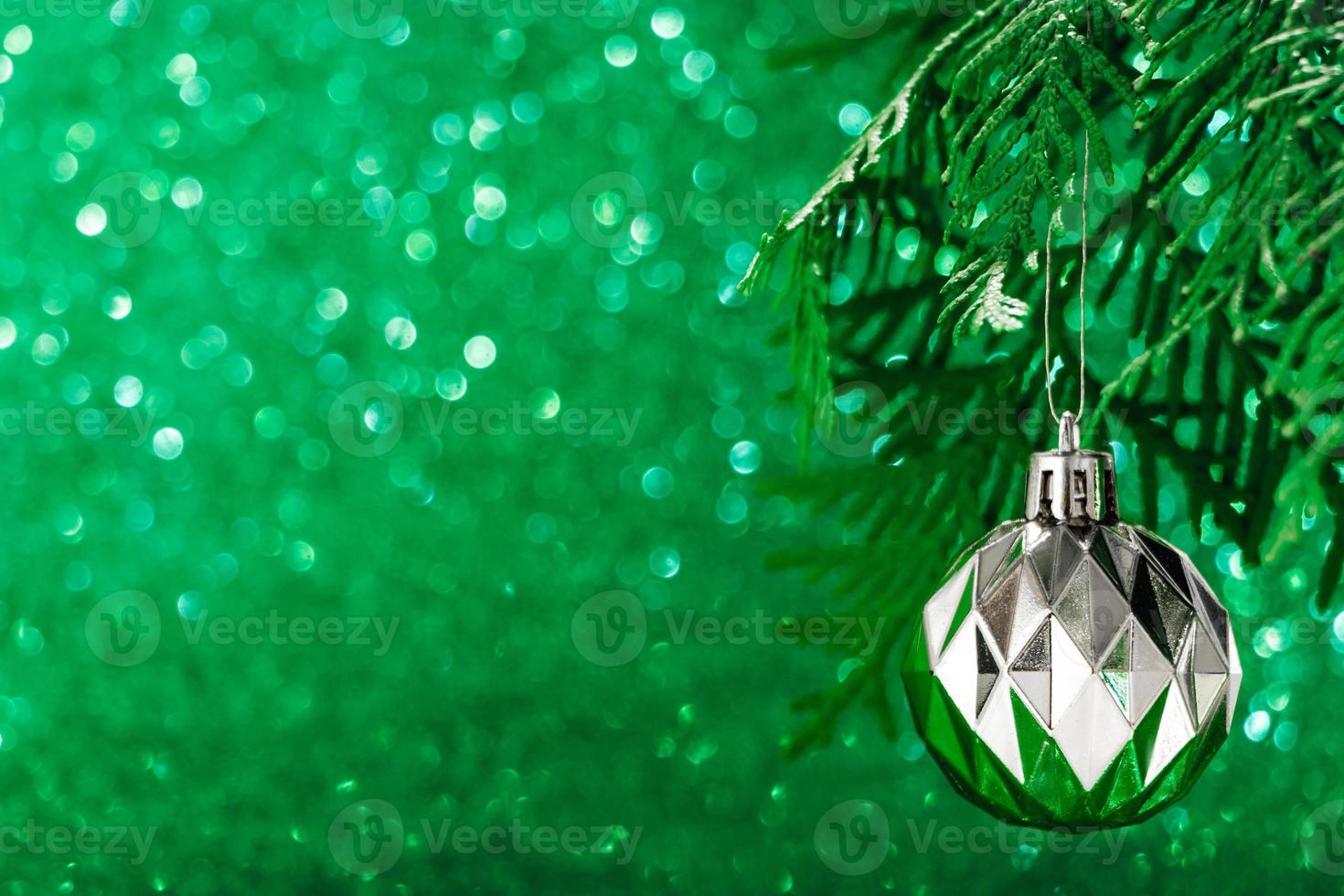 silver julboll på glänsande grön bakgrund. nytt år koncept foto